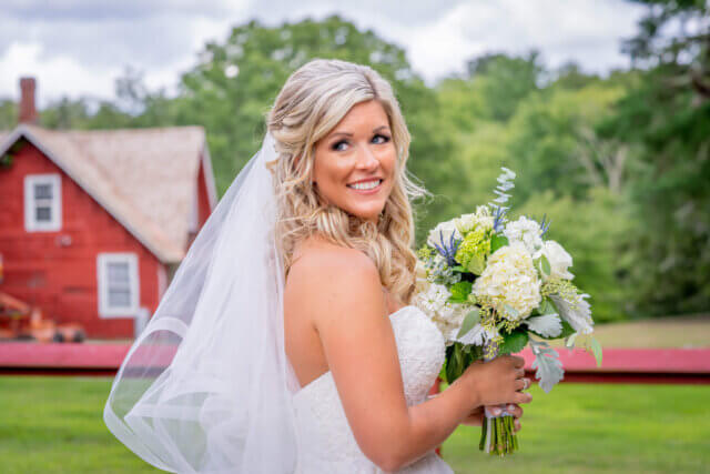 A bride holding a bouquet looks back